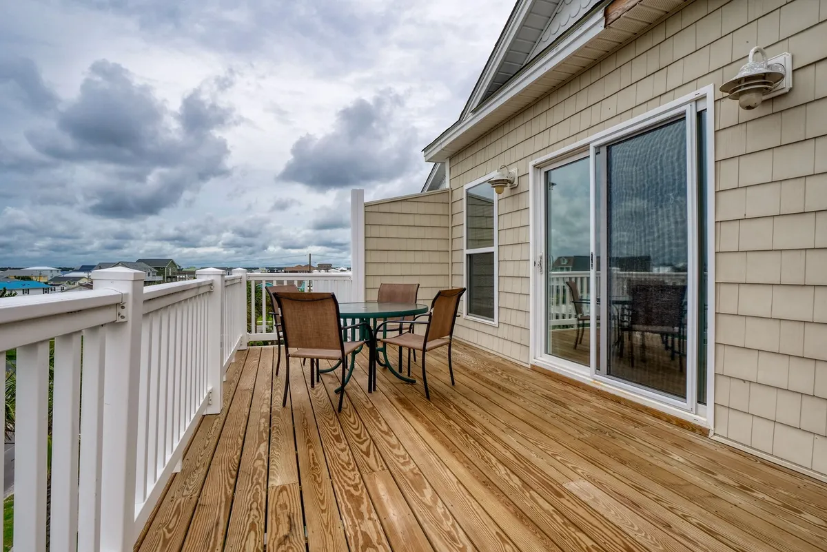 A tranquil wooden deck is set up with an outdoor dining set, facing a cloudy sky—suggesting a peaceful spot for gathering after a day out. The scene radiates relaxation, ideal for casual outdoor meals or unwinding after exploring local shops and attractions.