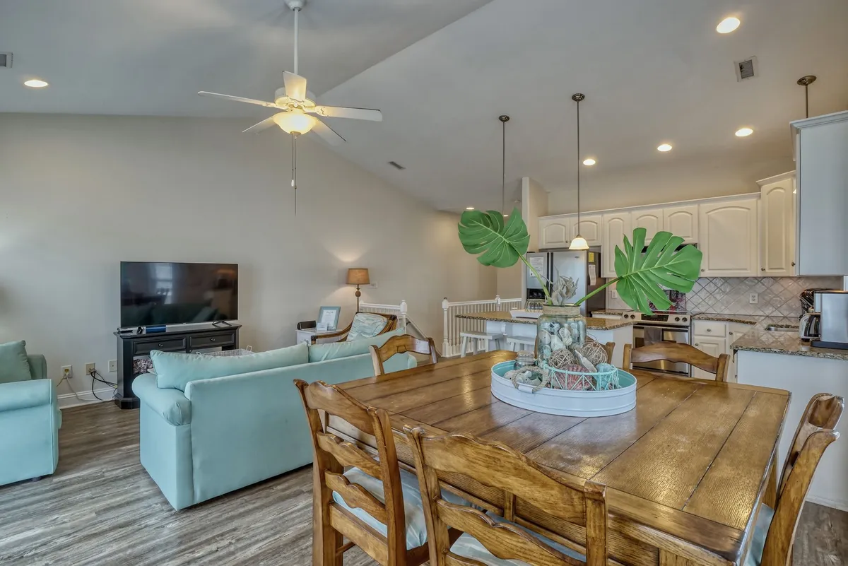 This photo highlights a cozy dining area adjacent to comfortable living room seating and a visible kitchen space. The arrangement is ideal for shared meals, social gatherings, and smooth transitions between cooking, dining, and relaxing.